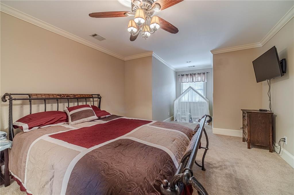 686 Newton Factory Bridge Road Covington, GA 30014 - Photo 45 of 110 a bedroom with a bed and a chandelier