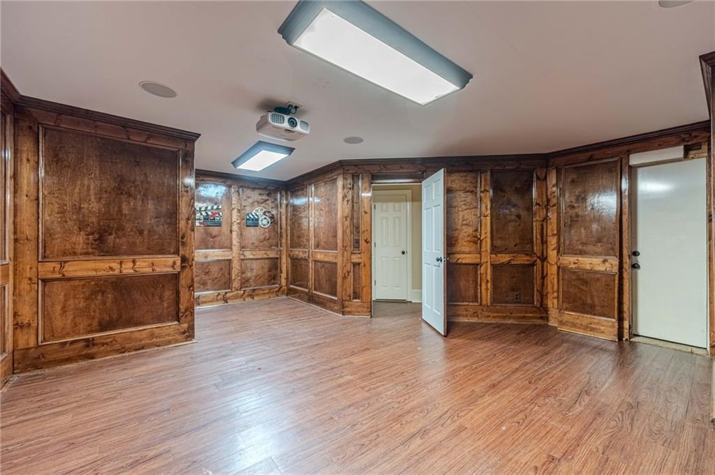 686 Newton Factory Bridge Road Covington, GA 30014 - Photo 49 of 110 an empty room with wooden floor and way to kitchen