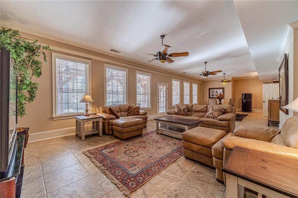 686 Newton Factory Bridge Road Covington, GA 30014 - Photo 56 of 110 a living room with furniture a flat screen tv and a large window