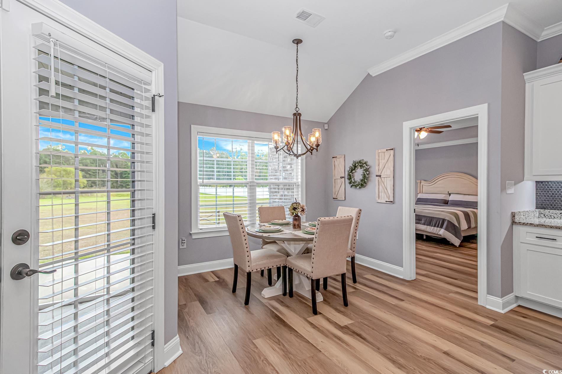 4082 Edwards Road Aynor, SC 29511 - Photo 11 of 40 Dining space featuring vaulted ceiling, crown molding, light wood-style floors, a chandelier, and ceiling fan