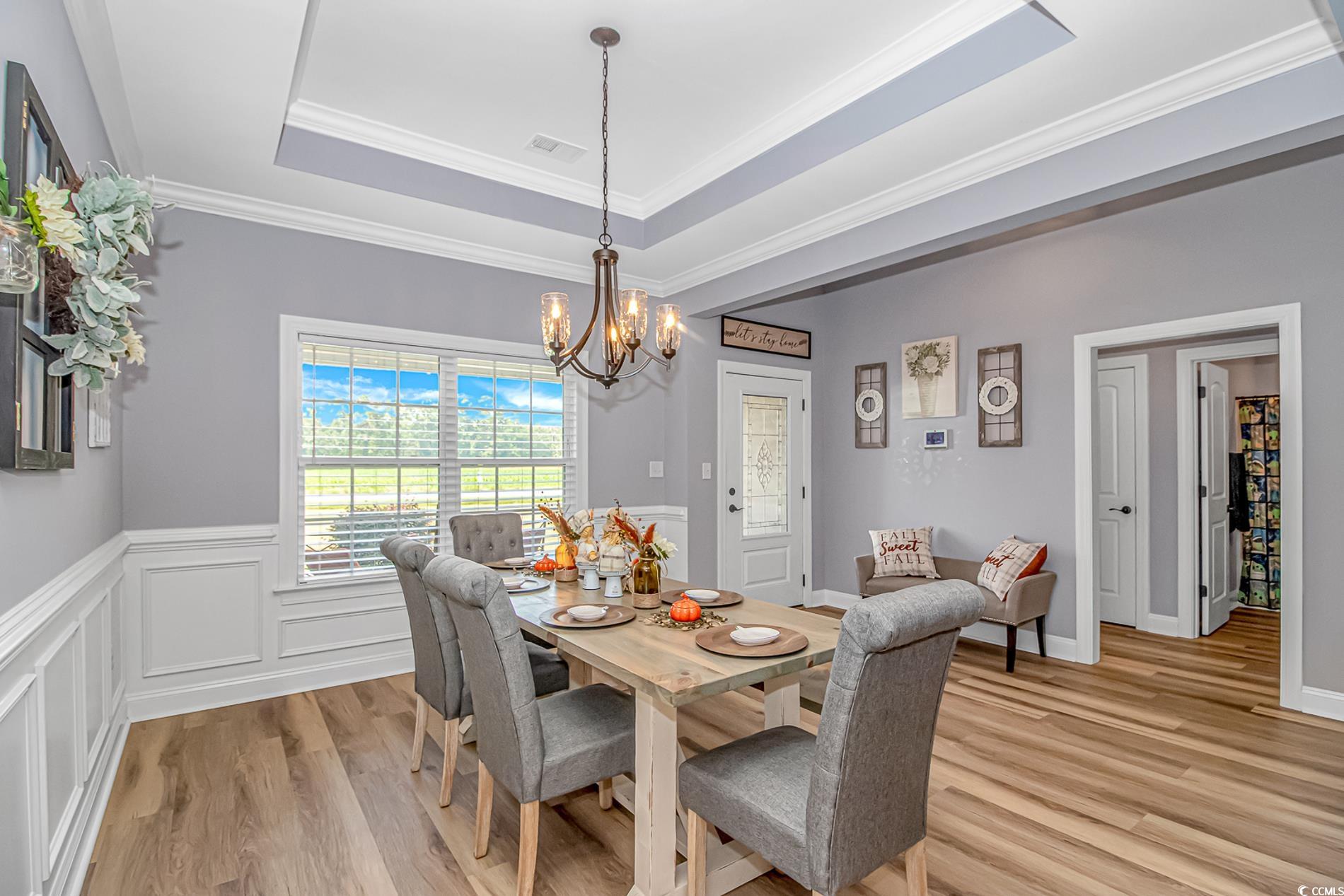 4082 Edwards Road Aynor, SC 29511 - Photo 4 of 40 Dining area with a tray ceiling, crown molding, light wood-style flooring, and a chandelier
