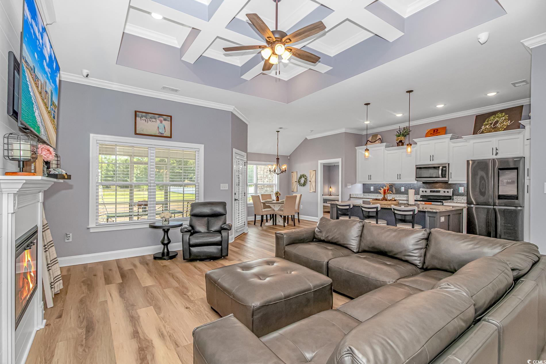 4082 Edwards Road Aynor, SC 29511 - Photo 6 of 40 Living room with crown molding, coffered ceiling, light wood finished floors, a glass covered fireplace, and ceiling fan