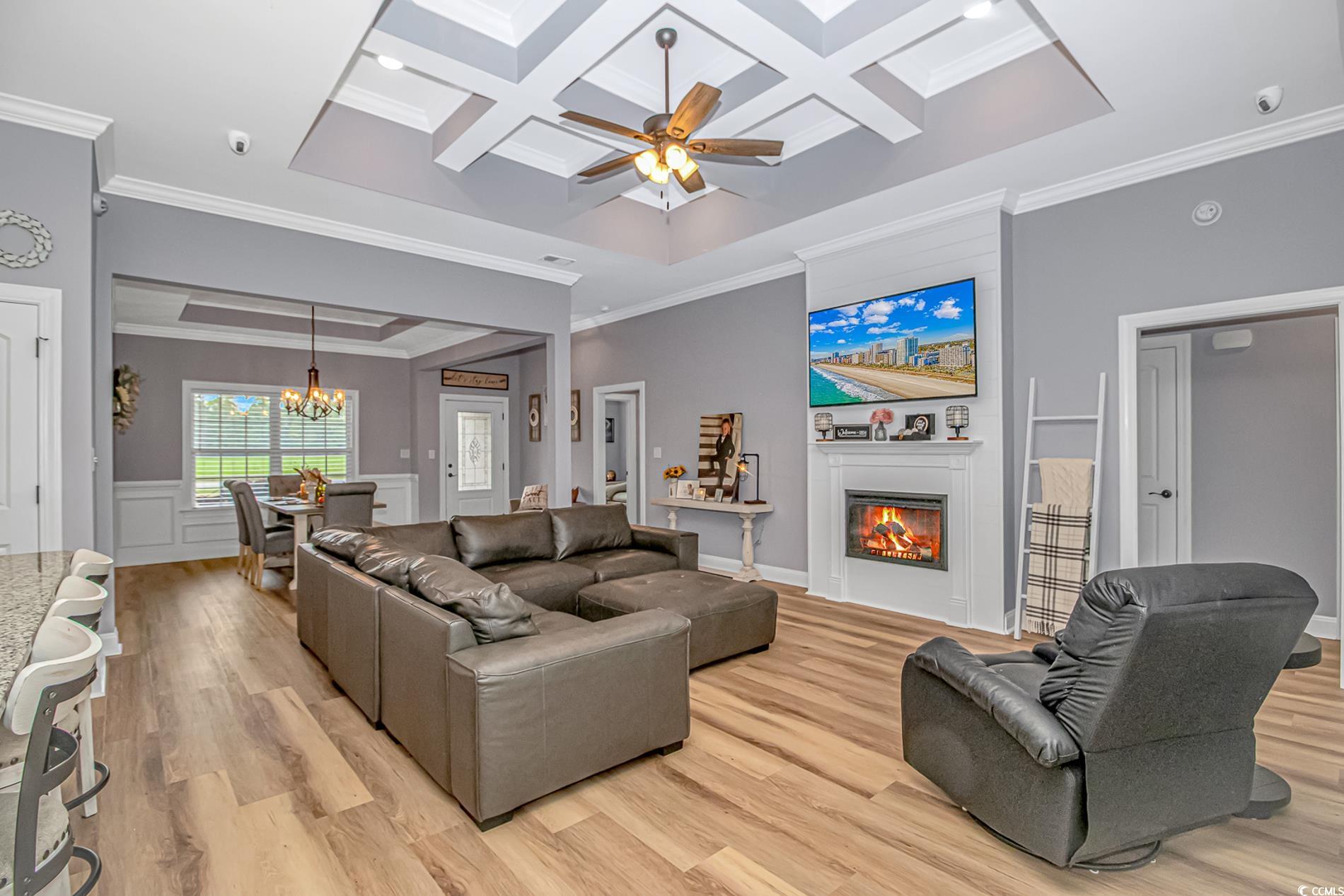 4082 Edwards Road Aynor, SC 29511 - Photo 7 of 40 Living room with coffered ceiling, ornamental molding, a warm lit fireplace, beamed ceiling, and ceiling fan