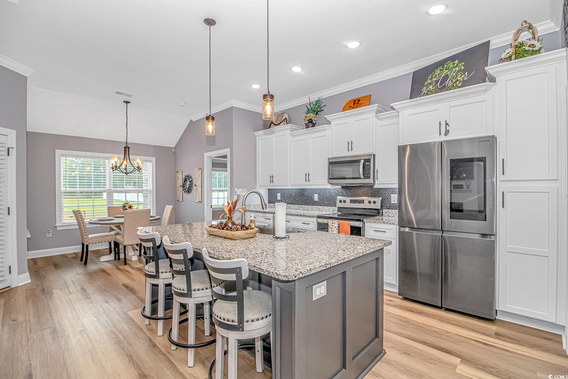 4082 Edwards Road Aynor, SC 29511 - Photo 8 of 40 Kitchen with decorative backsplash, stainless steel appliances, ornamental molding, pendant lighting, and white cabinets