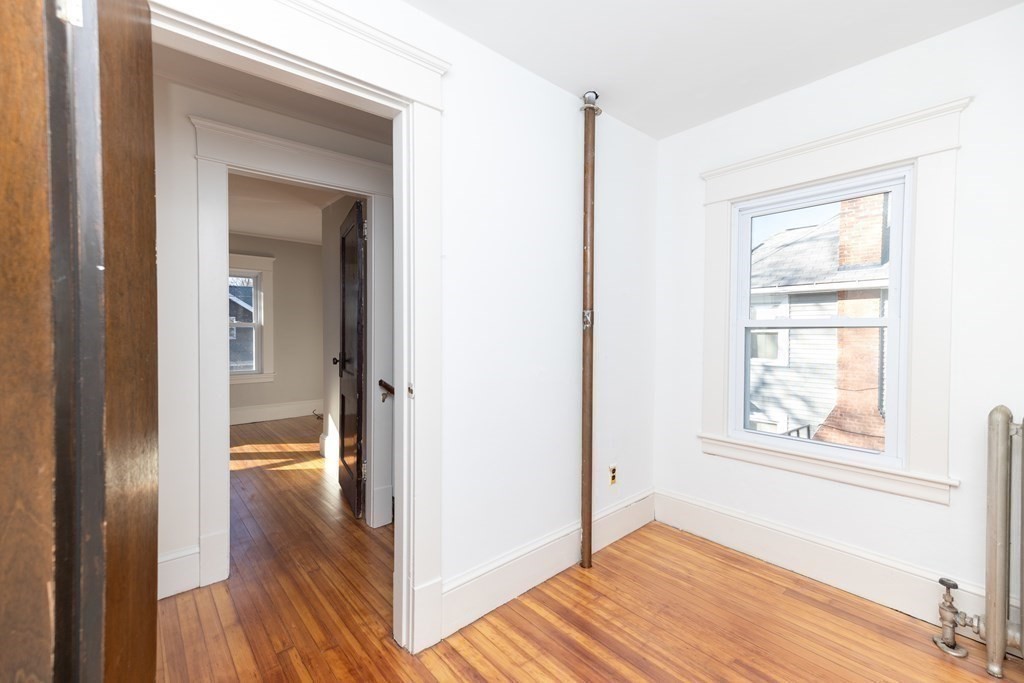 25 Daviston Street Springfield, MA 01108 - Photo 21 of 42 a view of an empty room with wooden floor and a window