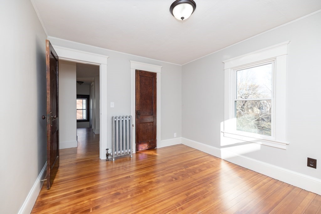 25 Daviston Street Springfield, MA 01108 - Photo 32 of 42 an empty room with wooden floor and windows