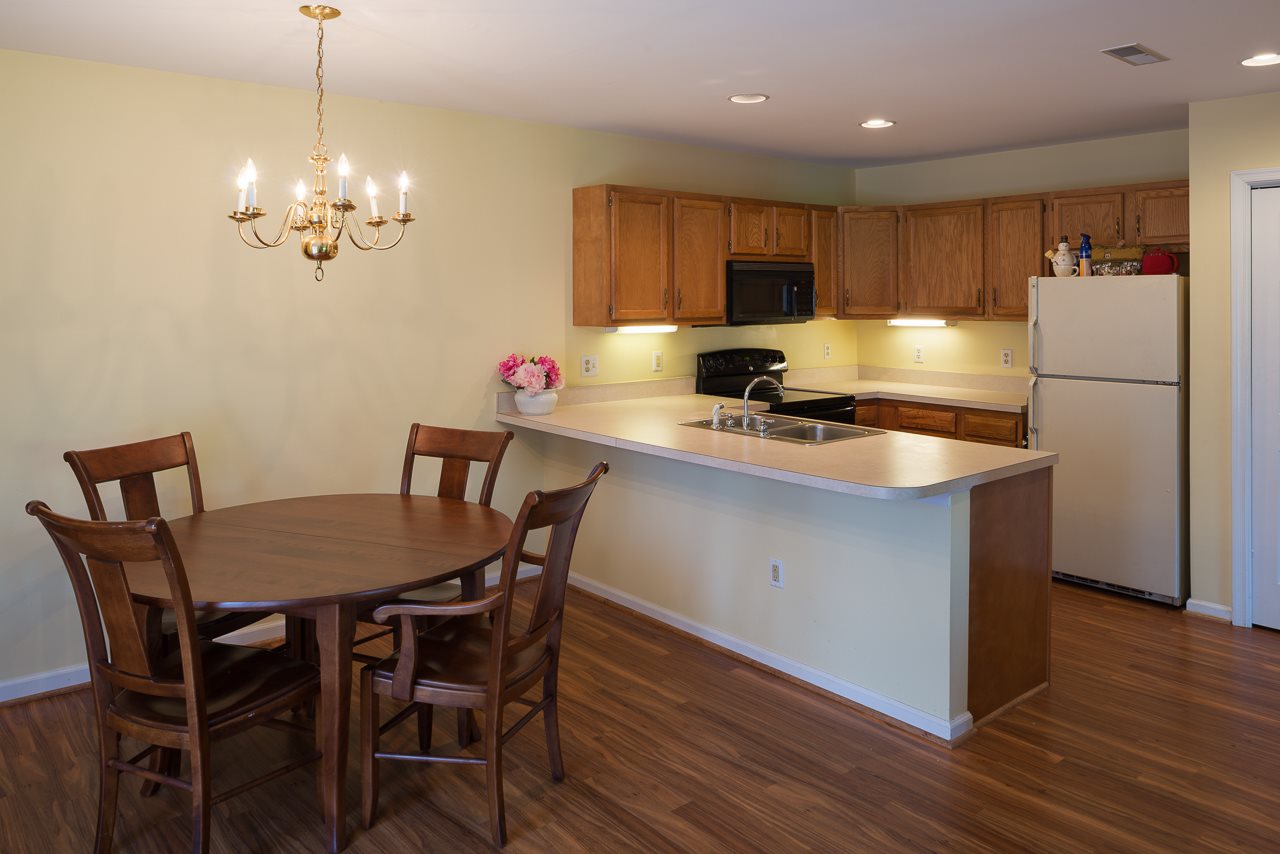 1053 Amber Ridge Road Charlottesville, VA 22901 - Photo 4 of 13 a kitchen with a dining table chairs refrigerator and cabinets