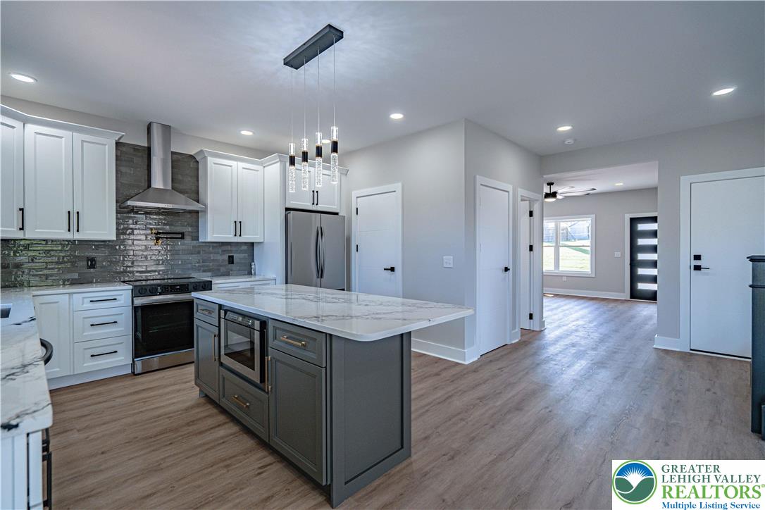 261 Maple Street Coplay, PA 18037 - Photo 11 of 53 a large kitchen with stainless steel appliances granite countertop a stove and a refrigerator