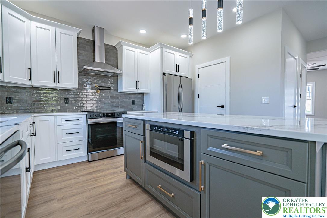 261 Maple Street Coplay, PA 18037 - Photo 12 of 53 a kitchen with stainless steel appliances kitchen island granite countertop a stove a sink and a refrigerator