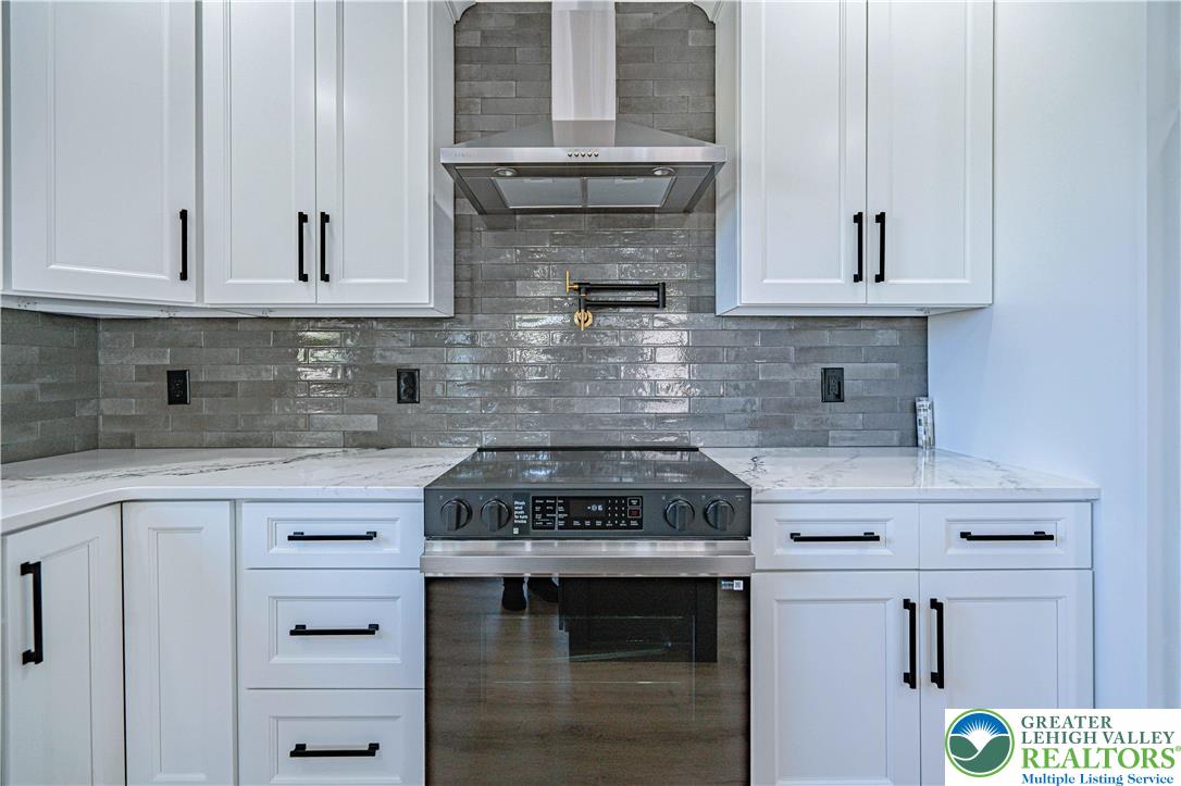 261 Maple Street Coplay, PA 18037 - Photo 16 of 53 a kitchen with granite countertop a stove sink and cabinets