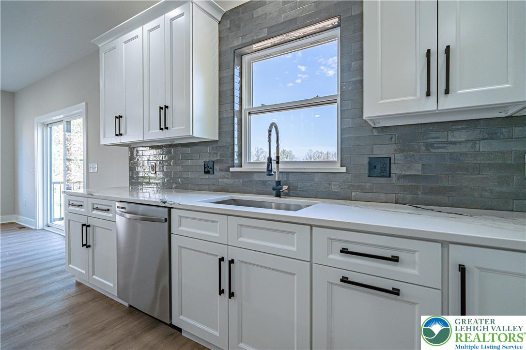 261 Maple Street Coplay, PA 18037 - Photo 17 of 53 a kitchen with stainless steel appliances granite countertop a sink and cabinets with wooden floor