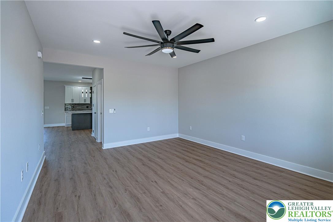 261 Maple Street Coplay, PA 18037 - Photo 8 of 53 a view of a big room with wooden floor and a ceiling fan