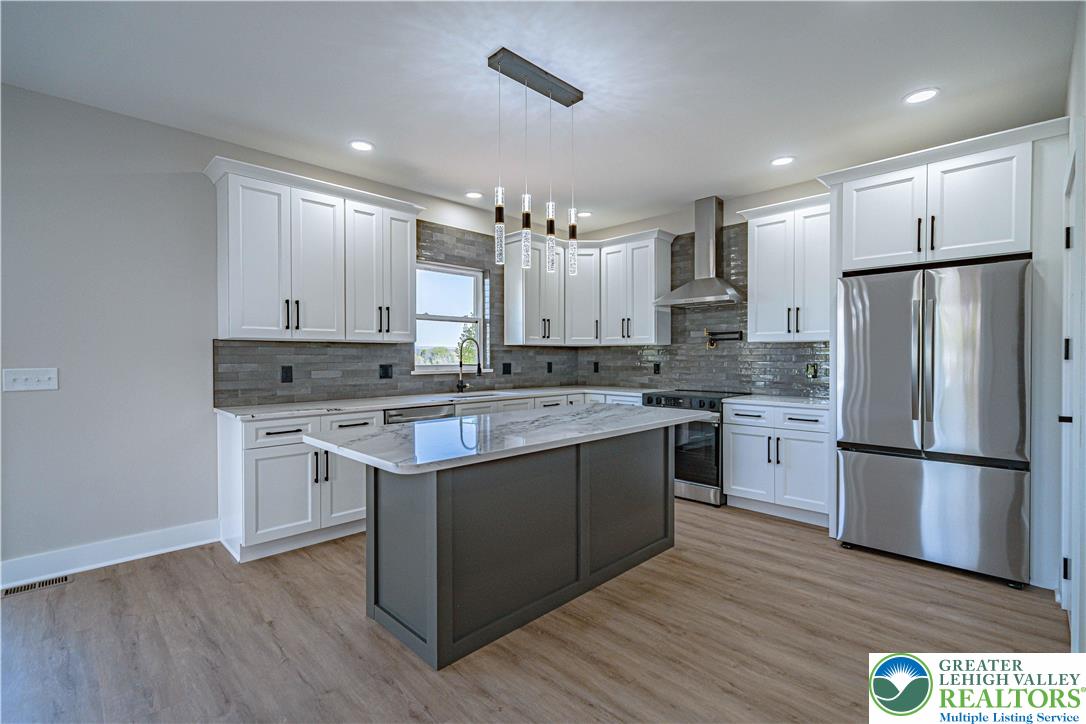 261 Maple Street Coplay, PA 18037 - Photo 10 of 53 a kitchen with kitchen island granite countertop a sink cabinets and stainless steel appliances