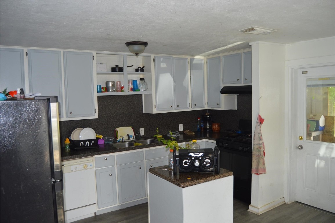 135 West 5th Street Kemah, TX 77565 - Photo 7 of 10 a kitchen with a refrigerator and cabinets