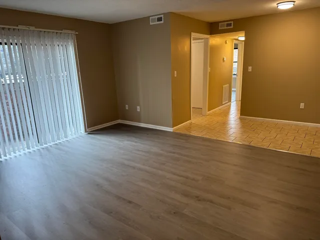 a view of an empty room with wooden floor