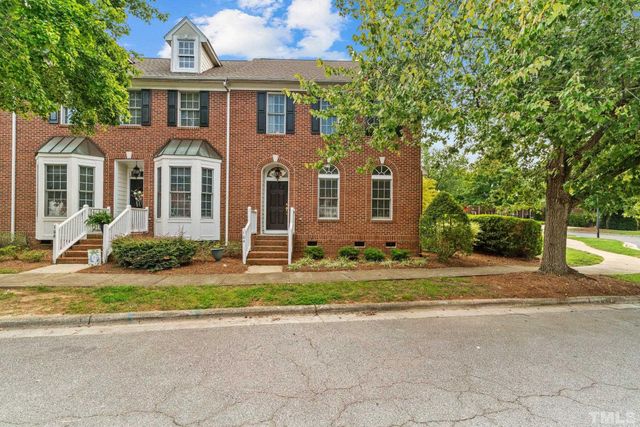 a front view of a house with a garden and trees