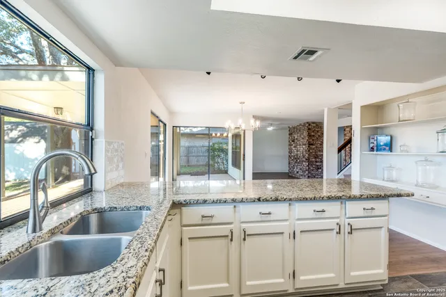 an empty room with wooden floor and ceiling fan