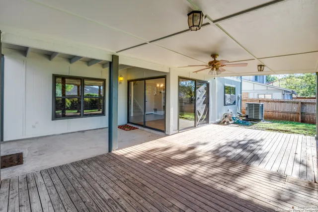 a view of a house with a yard and a large tree