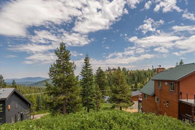 an aerial view of a house with yard street view and mountain view