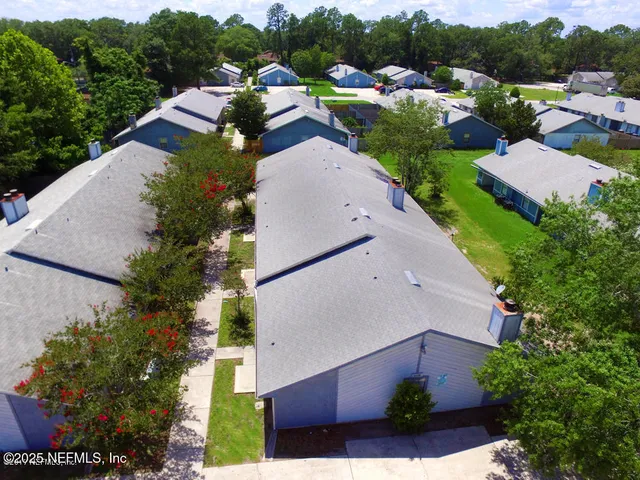 an aerial view of multiple houses with yard