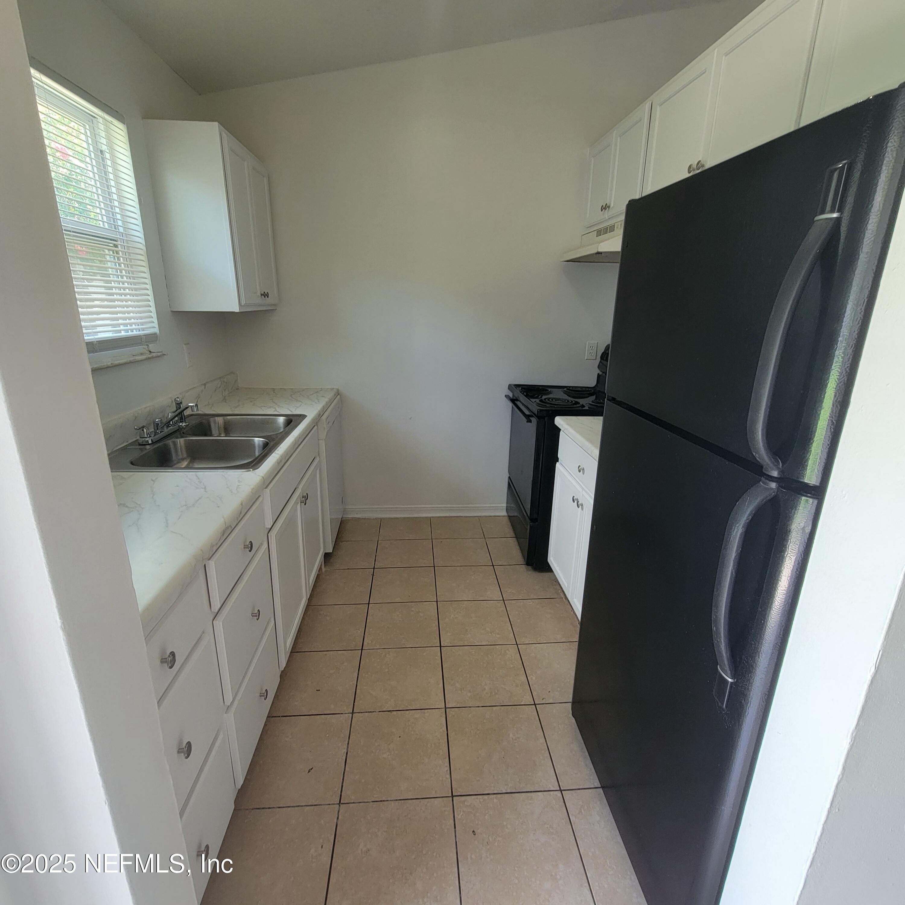 5138 Ricker Road, Unit 2 Jacksonville, FL 32210 - Photo 3 of 17 a kitchen with a sink and a stove top oven