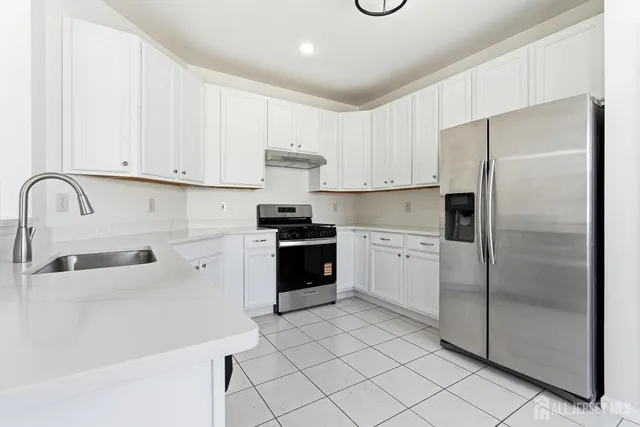 a kitchen with a refrigerator sink and cabinets