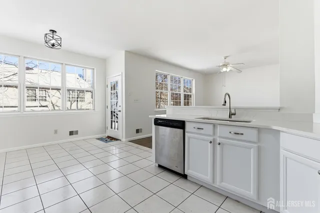 a kitchen with white cabinets and sink