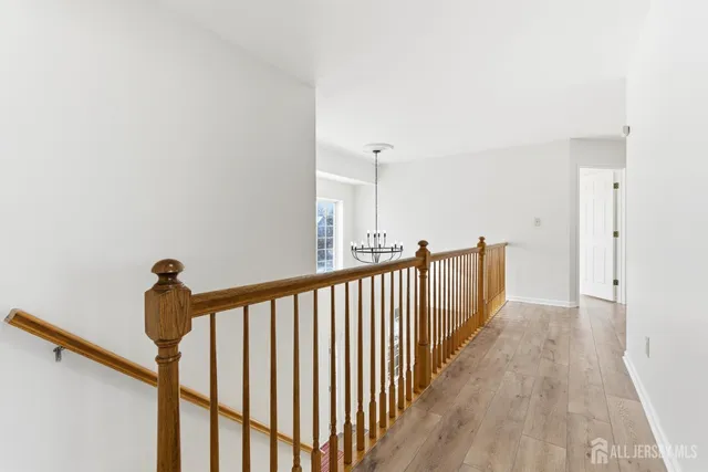 a view of a hallway with wooden floor and stairs