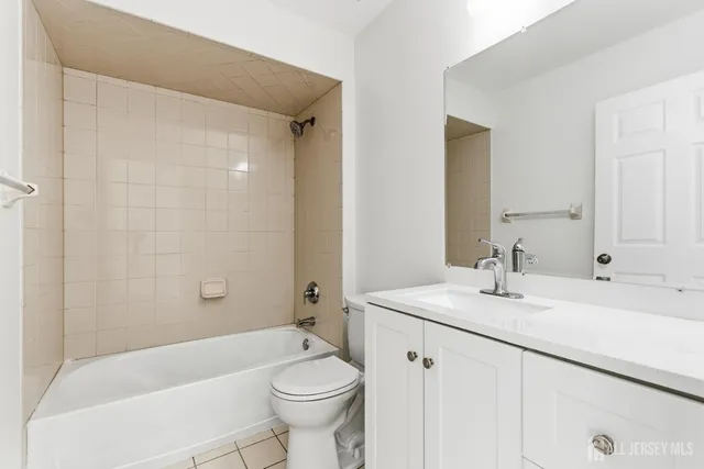 a bathroom with a sink a toilet a mirror a bathtub and shower