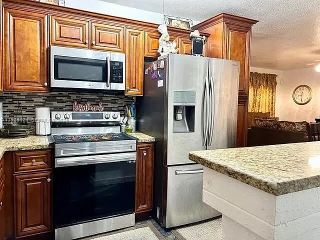 a kitchen with stainless steel appliances granite countertop a sink and a window