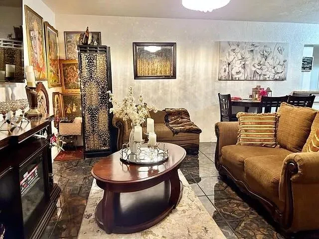 a living room with furniture and a painting on the wall