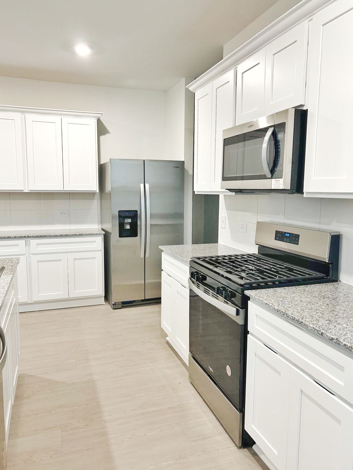 14973 Rustic Moon Road Conroe, TX 77302 - Photo 6 of 22 a kitchen with stainless steel appliances granite countertop a stove a microwave and a refrigerator