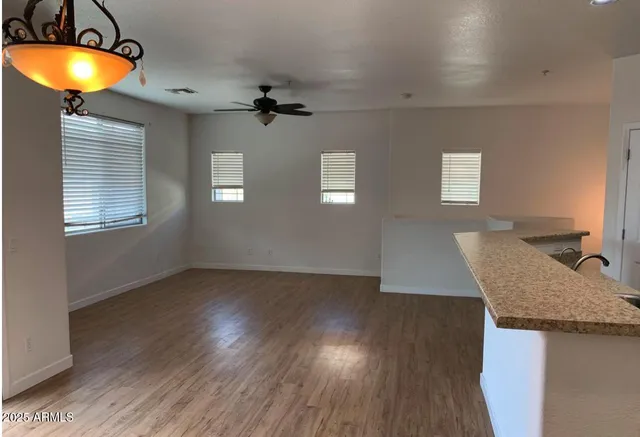 a kitchen with a sink a chandelier and wooden floor