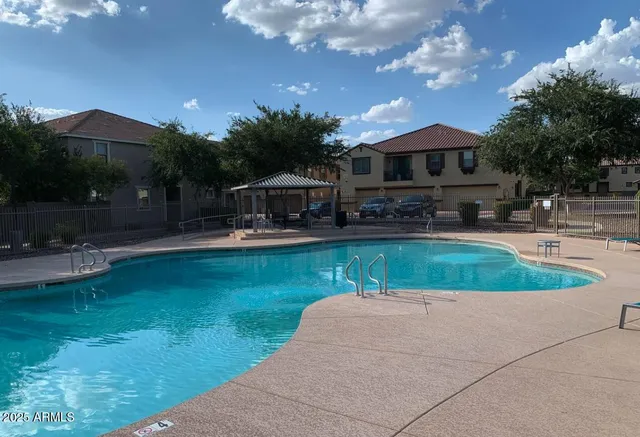 a house view with swimming pool and trees