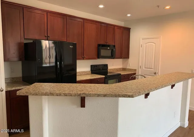 a kitchen with granite countertop a refrigerator and a sink