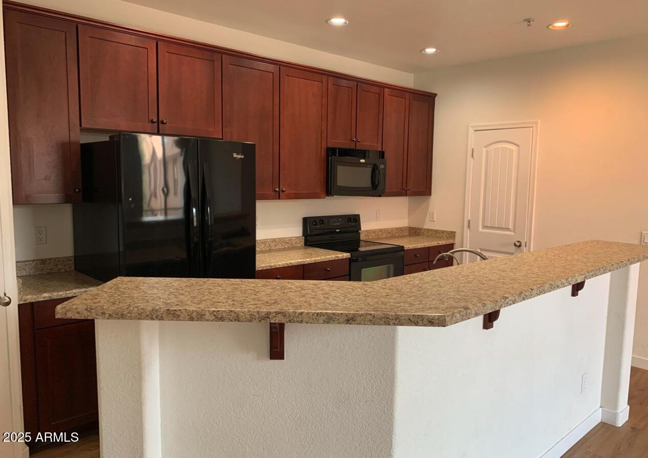 1265 South Aaron, Unit 305 Mesa, AZ 85209 - Photo 6 of 25 a kitchen with granite countertop a refrigerator and a sink