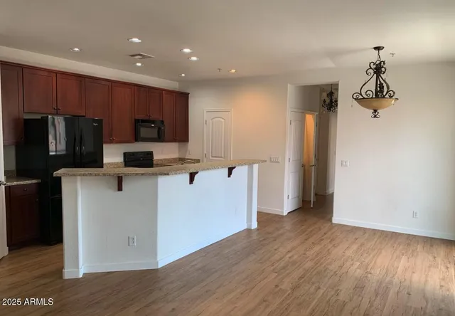 a kitchen with a refrigerator a stove and a wooden floor