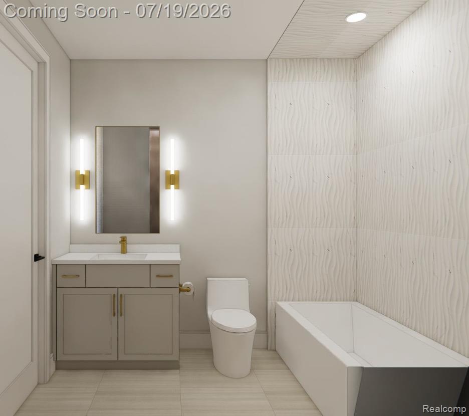 2585 Fairway Court Rochester, MI 48306 - Photo 17 of 19 Bathroom featuring a rectangular soaking tub with textured wall tiling, a vanity with a white countertop and gold-tone fixtures, and coordinated floor tiling