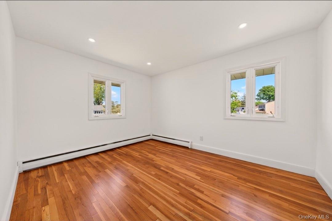 8 White Birch Lane Commack, NY 11725 - Photo 14 of 44 a view of an empty room with wooden floor and a window