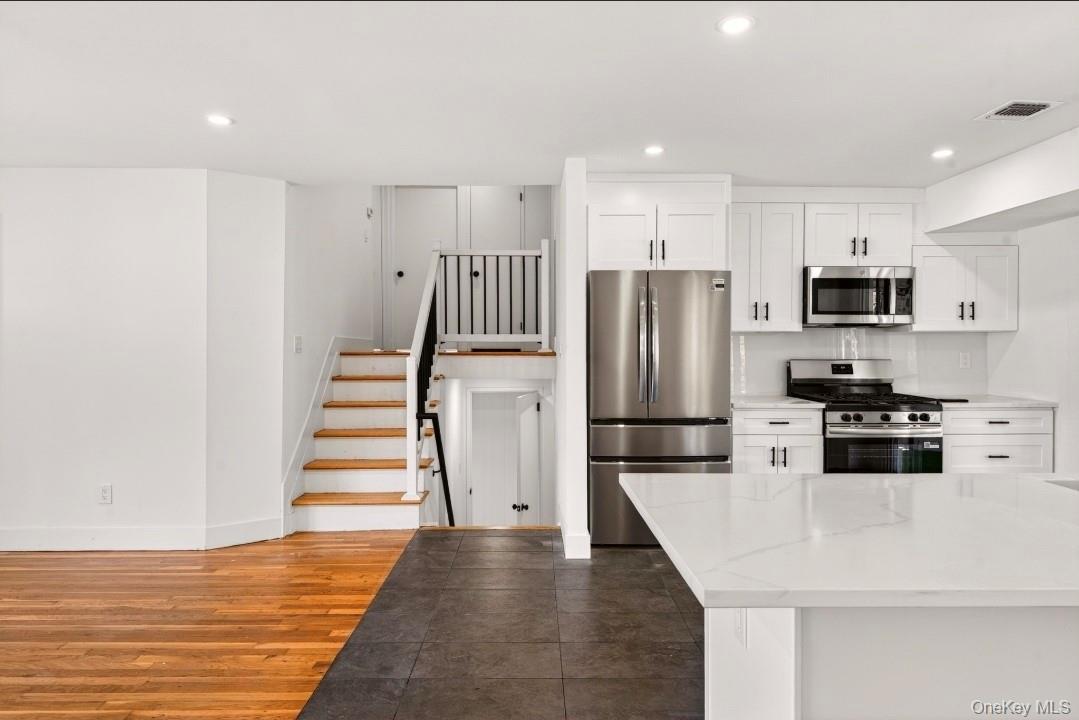 8 White Birch Lane Commack, NY 11725 - Photo 10 of 44 a kitchen with stainless steel appliances a refrigerator stove microwave and cabinets