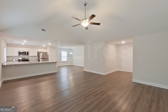 110 Western Red Cedar Drive Springfield, GA 31329 - Photo 3 of 19 a view of an empty room and kitchen with wooden floor
