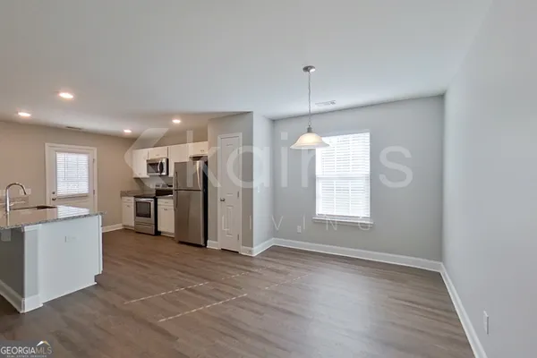 a view of a kitchen with a sink a refrigerator and window