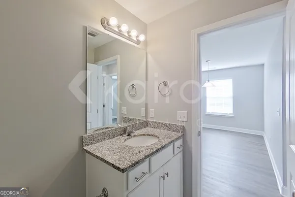a bathroom with a granite countertop sink a mirror and a vanity