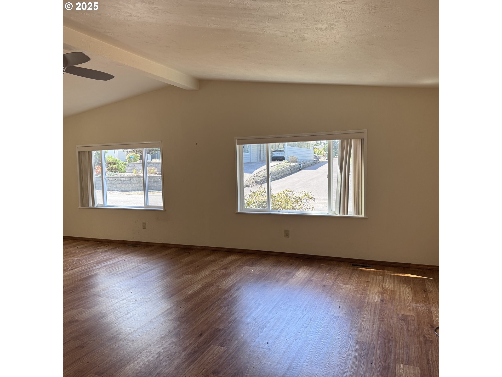 1601 Rhododendron Drive, Unit 695 Florence, OR 97439 - Photo 18 of 42 a view of an empty room with wooden floor and a window