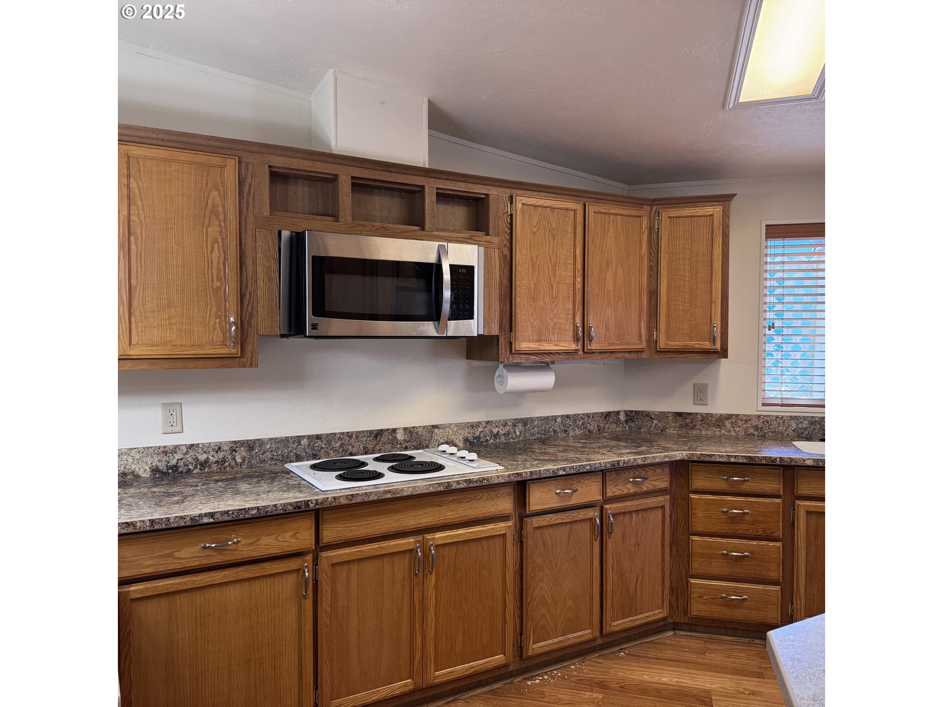 1601 Rhododendron Drive, Unit 695 Florence, OR 97439 - Photo 22 of 42 a kitchen with granite countertop a stove microwave and sink