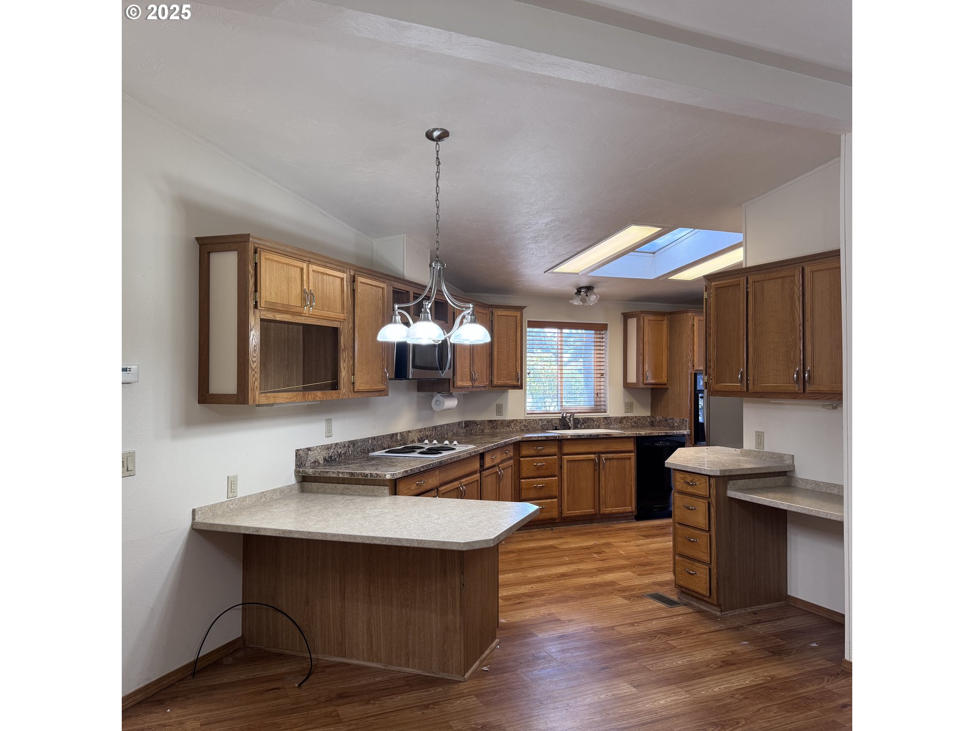 1601 Rhododendron Drive, Unit 695 Florence, OR 97439 - Photo 23 of 42 a kitchen with stainless steel appliances granite countertop a sink a stove and a wooden floors