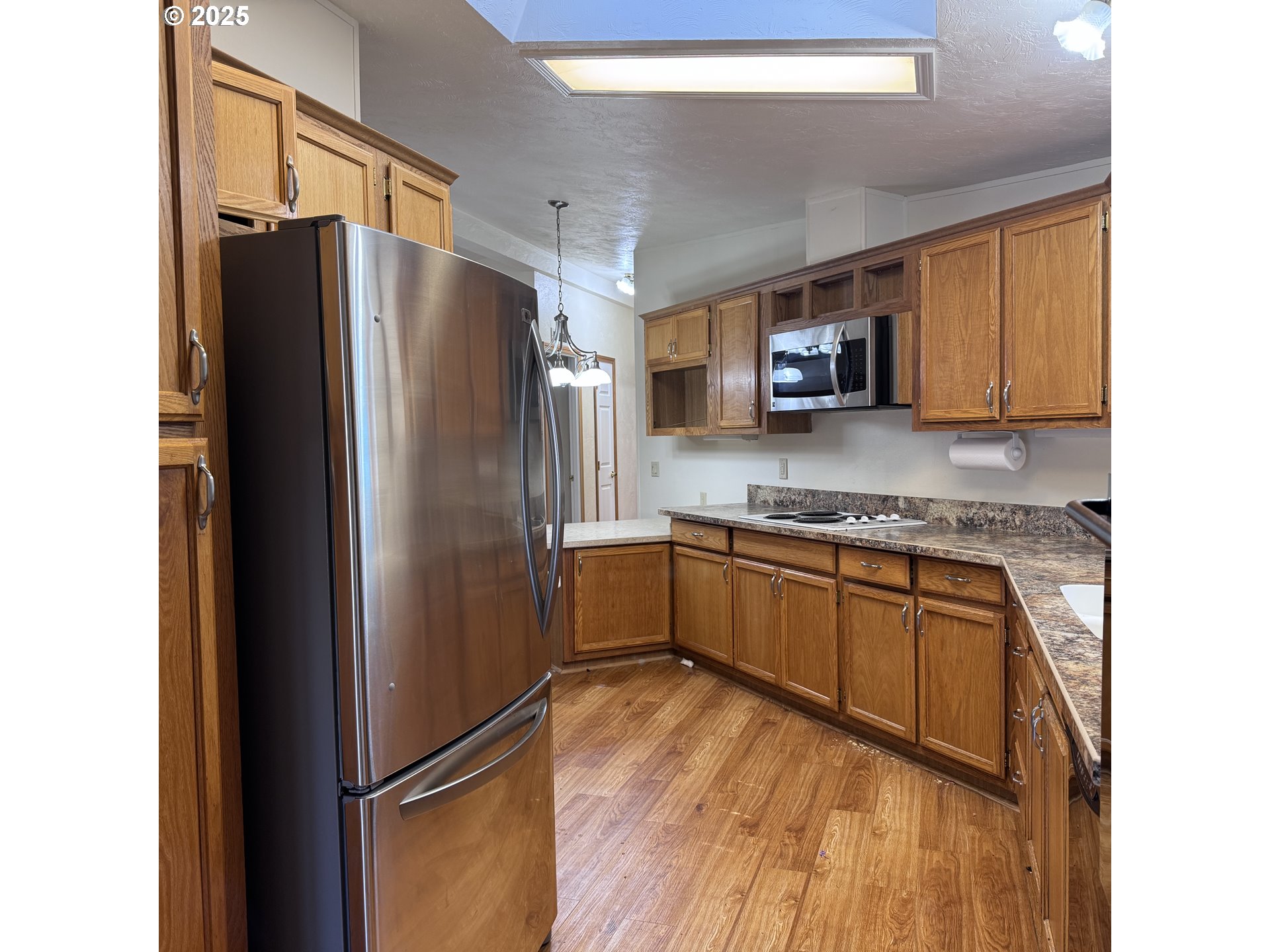 1601 Rhododendron Drive, Unit 695 Florence, OR 97439 - Photo 25 of 42 a kitchen with stainless steel appliances granite countertop a refrigerator and a stove top oven