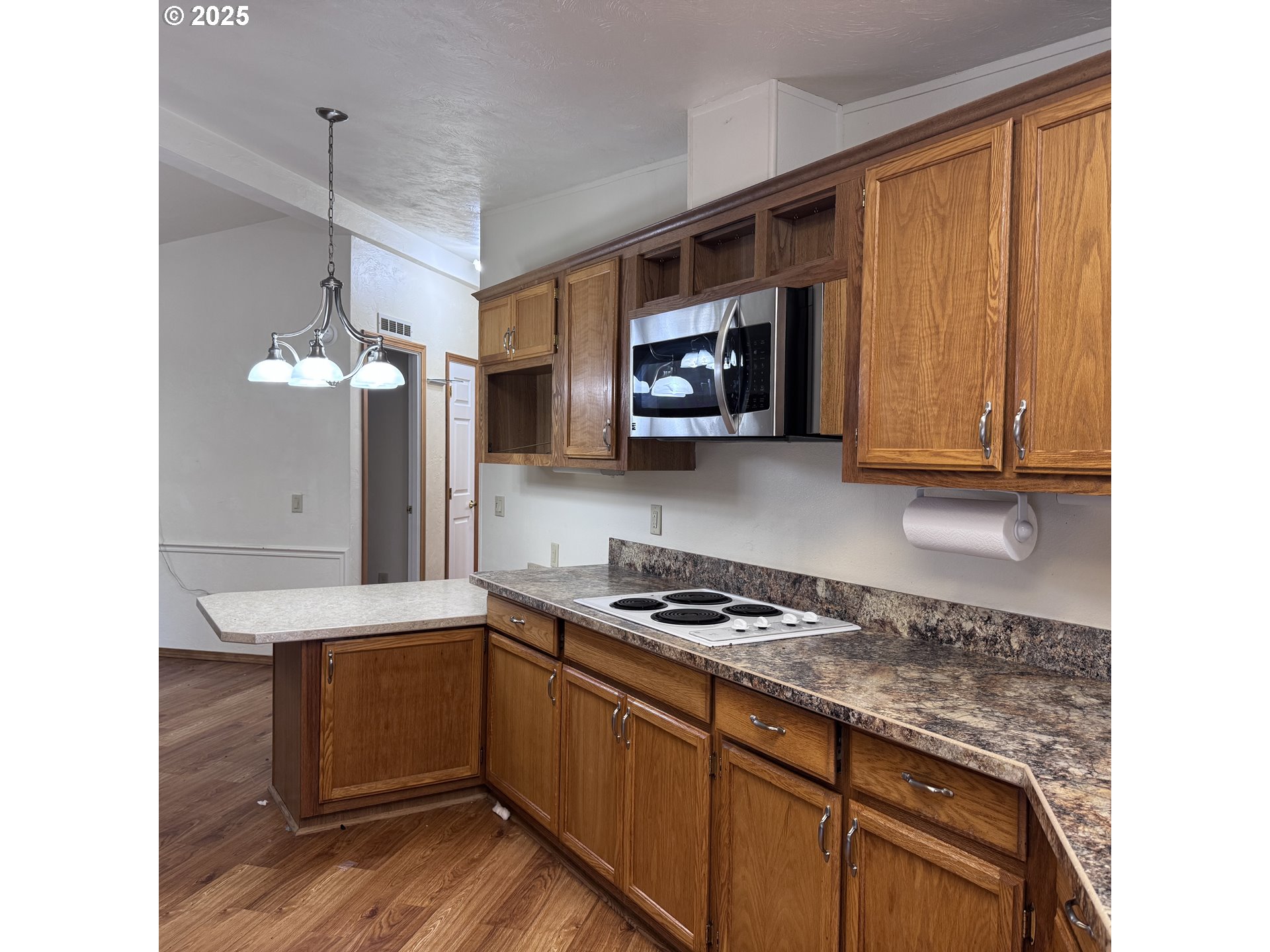 1601 Rhododendron Drive, Unit 695 Florence, OR 97439 - Photo 26 of 42 a kitchen with stainless steel appliances granite countertop a stove a sink and a microwave