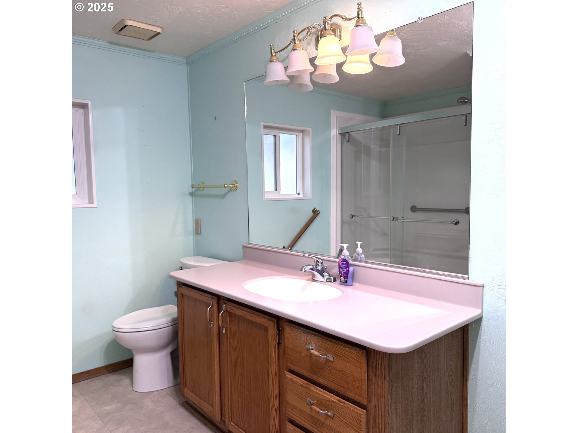 1601 Rhododendron Drive, Unit 695 Florence, OR 97439 - Photo 36 of 42 a bathroom with a sink a toilet and a large mirror