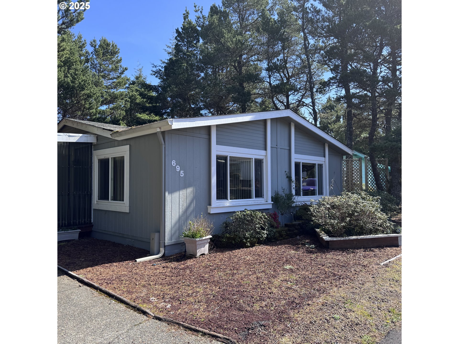 1601 Rhododendron Drive, Unit 695 Florence, OR 97439 - Photo 7 of 42 a front view of a house with garden